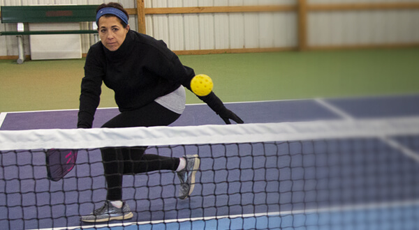 woman with paddle playing pickleball