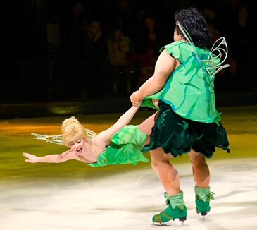 Bre dressed as a green fairy mid air as another skater spins her around
