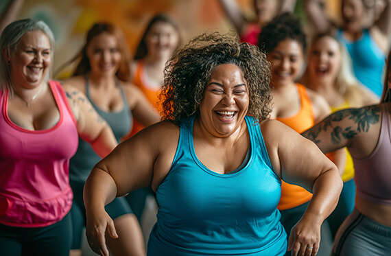 A group of women smiling during a fitness dance class